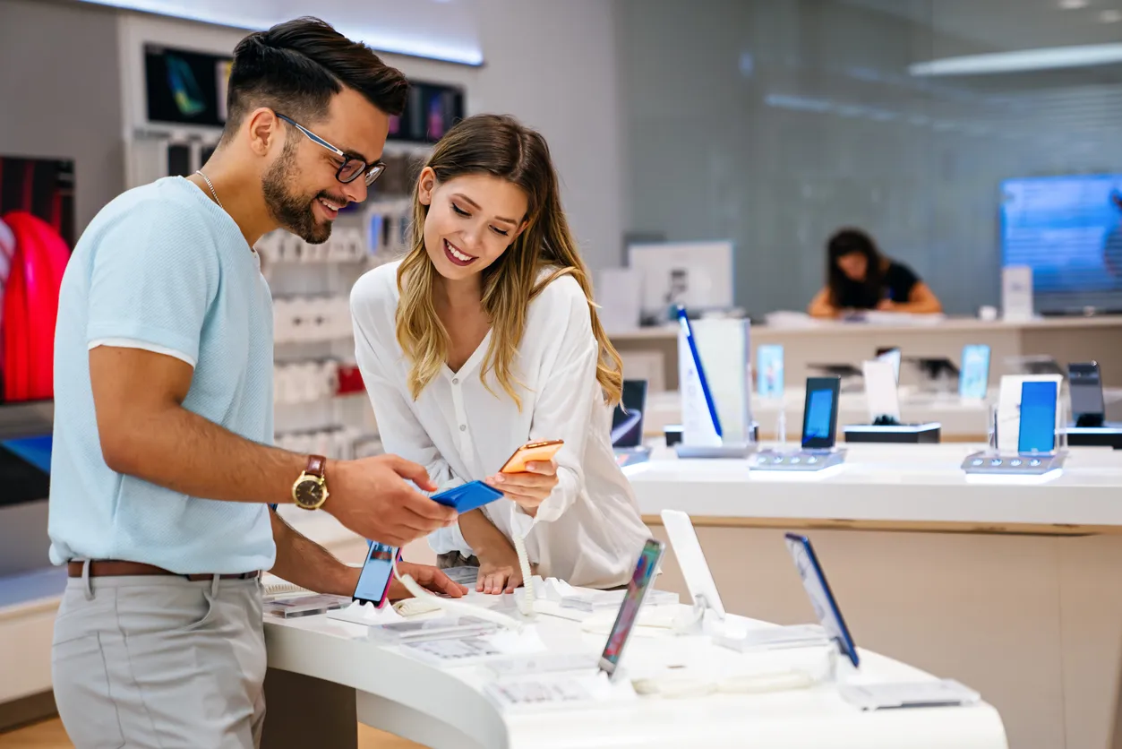 Pareja feliz comprando un smartphone en la tienda