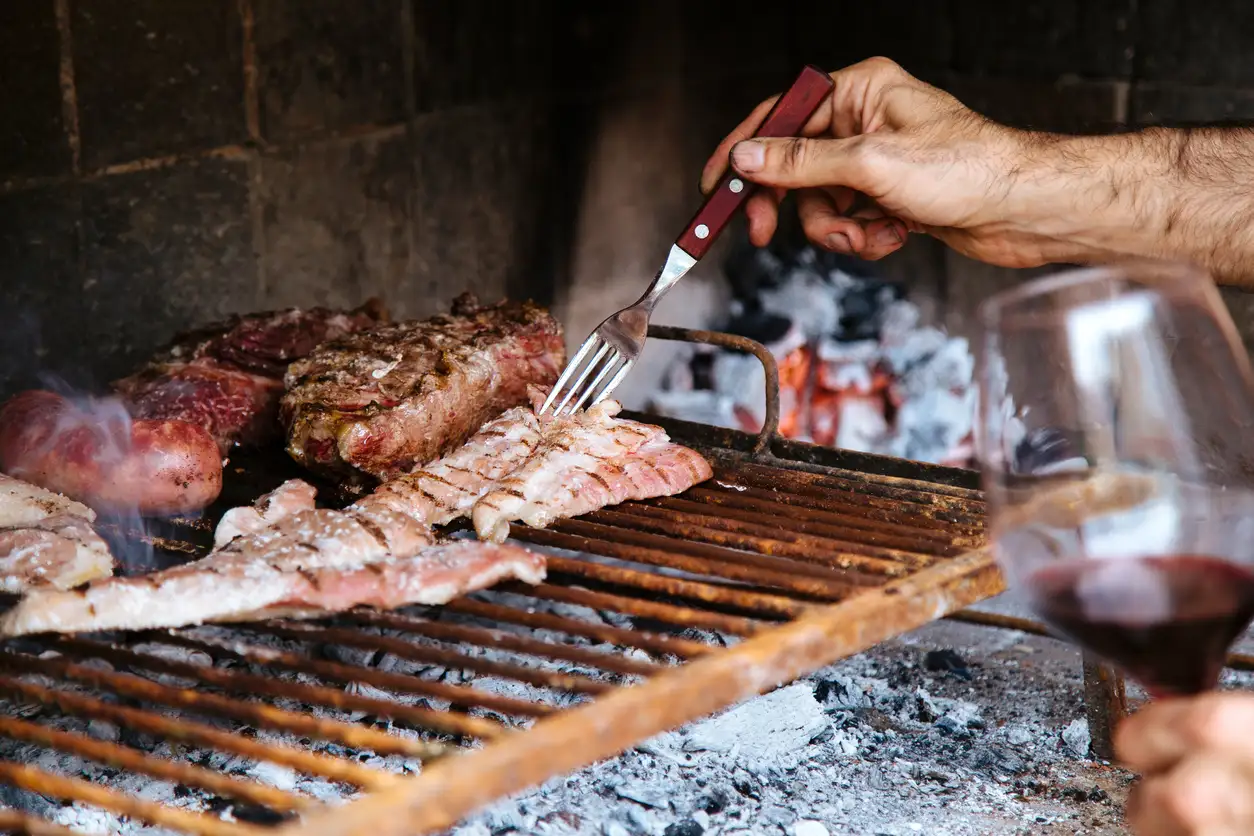 Hombre cocinando carne asada