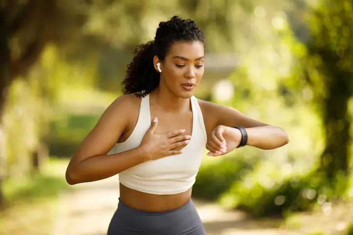 mujer deportista usando su smartwatch para revisar ritmo cardiaco