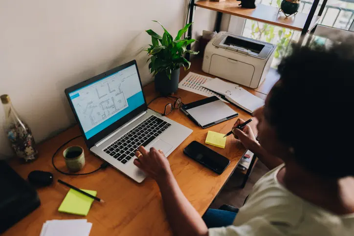 mujer realizando un trabajo para la universidad e imprime en su escritorio