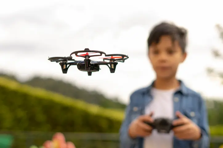 niño manejando un dron en el parque
