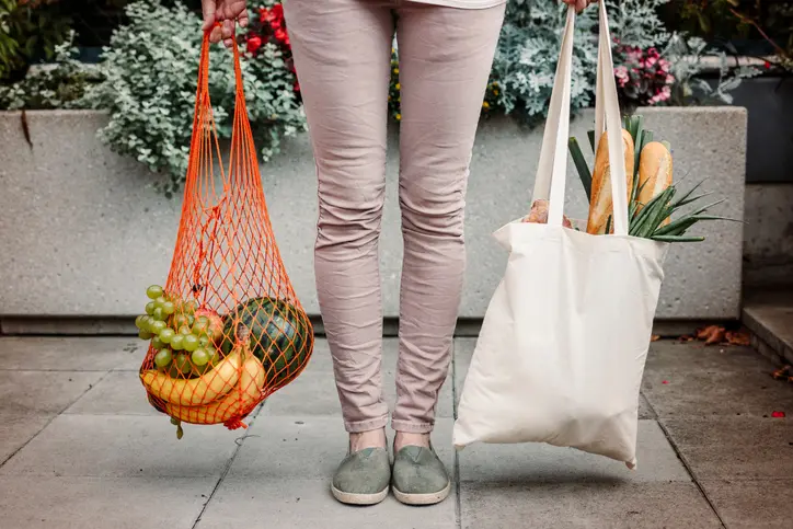 mujer tomando acciones medio ambiente con bolsas ecologicas