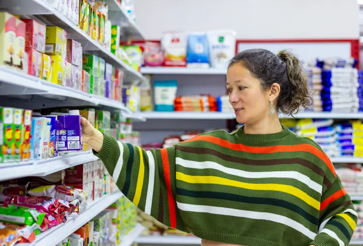 mujer aprovechando los espacios para acomodar los abarrotes en tienda